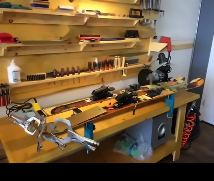 Ski held in a vise at the workbench during a top sheet repair