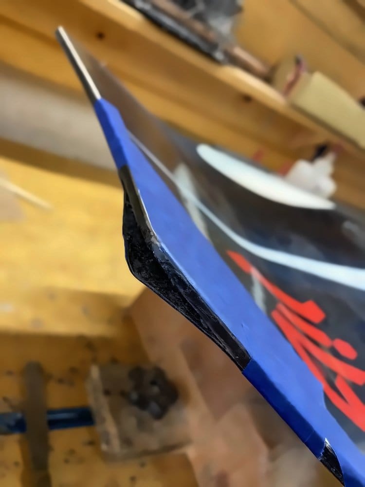 Damaged ski tip clamped and ready for repair