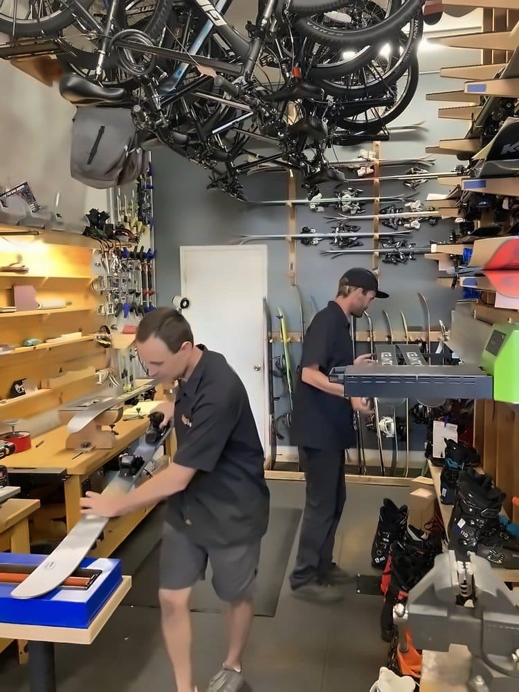 Two technicians at work, one at the bench and one at the wax machine