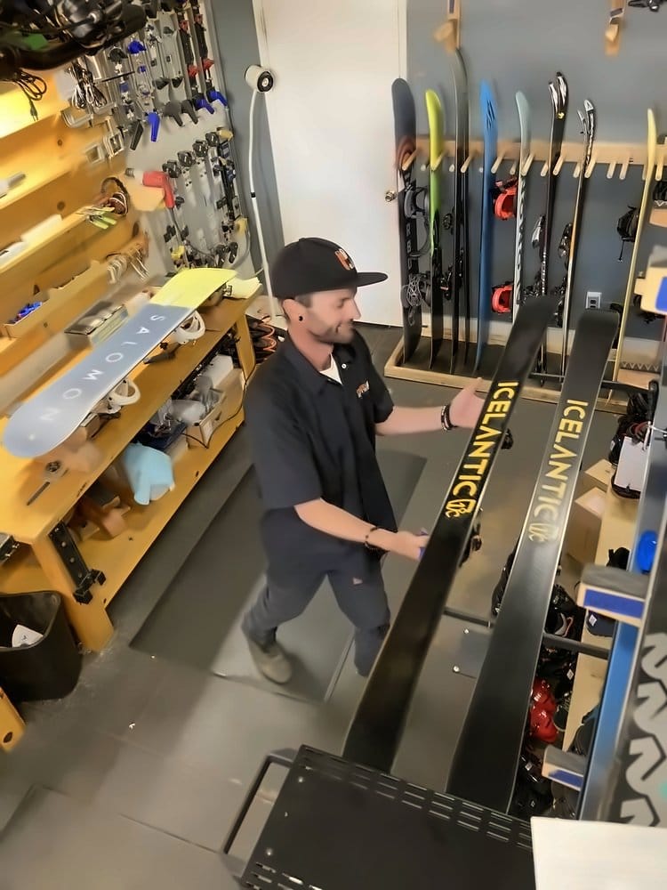 Technician racking a pair of Icelantic skis after service