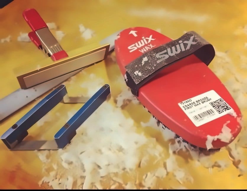Swix wax brush and edge tools on a pile of wax shavings