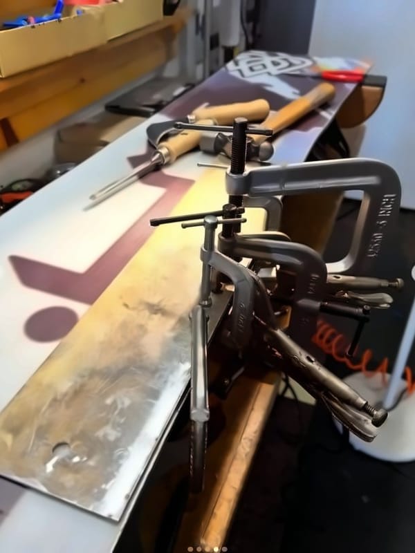 Base patch clamped onto a snowboard while the epoxy cures