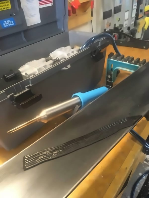 Base welder and P-tex material on the bench beside the ski being repaired